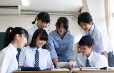 선생님과 책상에서 타블렛pc를 보고 있는 중학생 5명 사진 사진